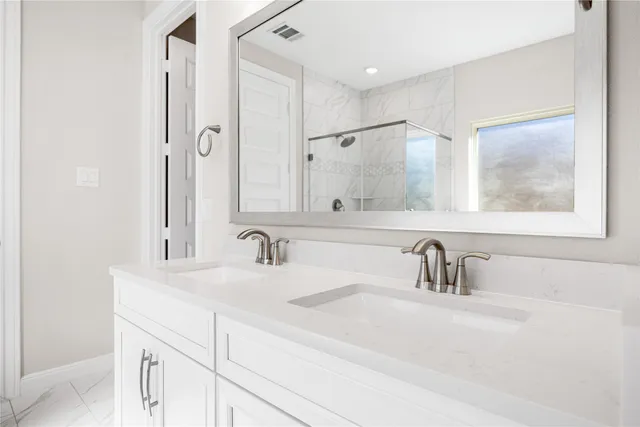 a bathroom with double vanity sink and a mirror