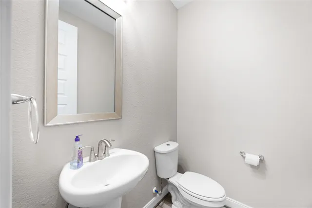 a bathroom with a toilet a sink and mirror