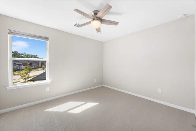 an empty room with a window and a fan