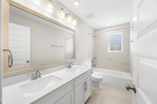 a bathroom with a double vanity sink toilet and shower