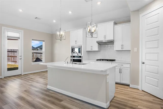 a kitchen with stainless steel appliances granite countertop a sink a stove and a refrigerator