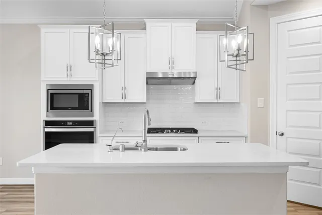 a kitchen with stainless steel appliances a white stove top oven and cabinets