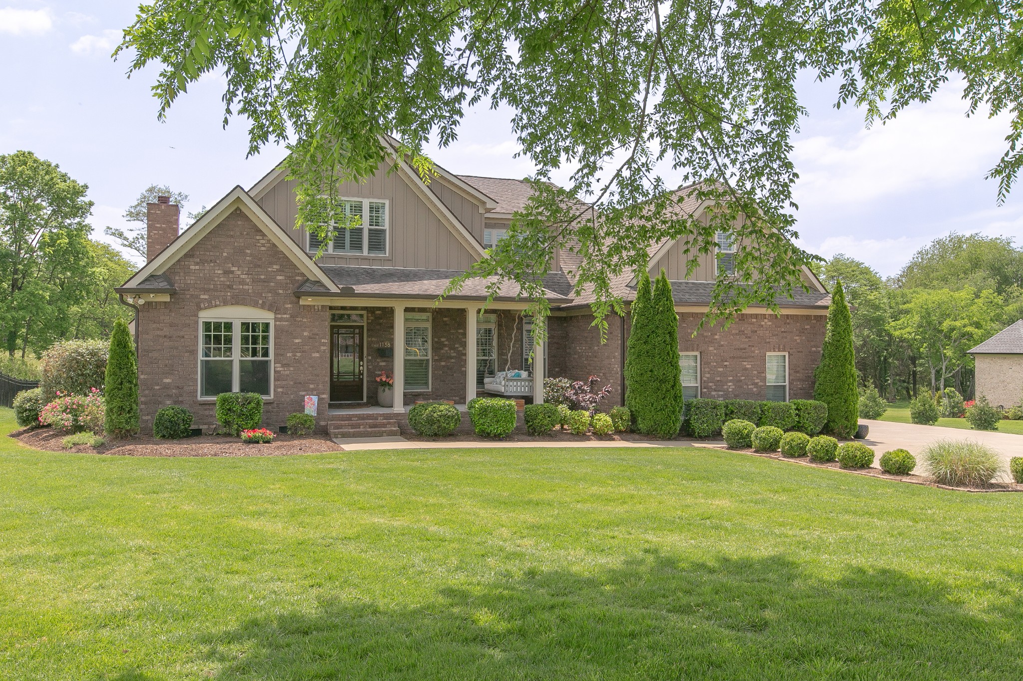 a front view of a house with a yard and trees