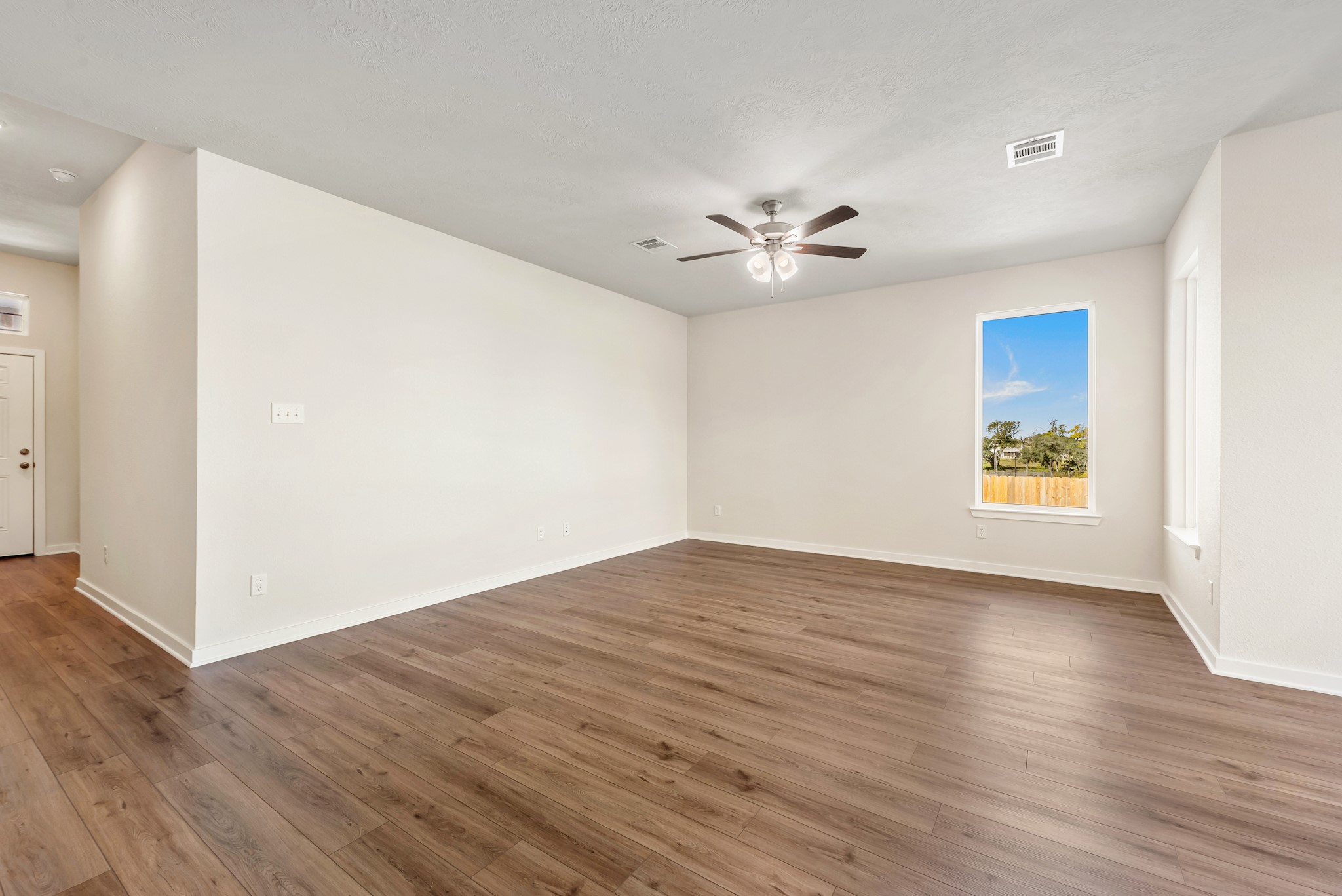 1456 Lk Rdg Drive Brenham, TX 77833 - Photo 11 of 34 a view of an empty room with wooden floor and a ceiling fan