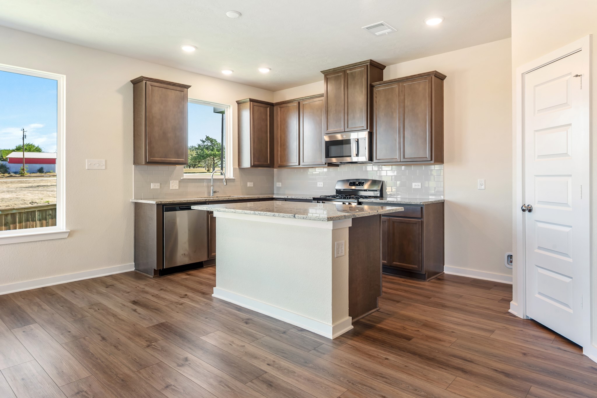 1456 Lk Rdg Drive Brenham, TX 77833 - Photo 14 of 34 a kitchen with stainless steel appliances granite countertop a sink a stove a refrigerator cabinets and a wooden floor