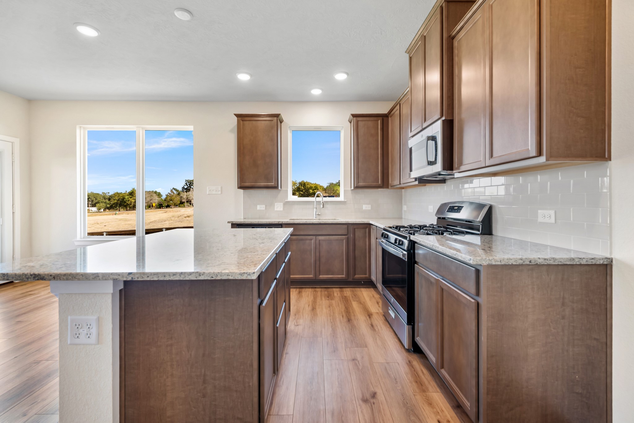1456 Lk Rdg Drive Brenham, TX 77833 - Photo 19 of 34 a kitchen with stainless steel appliances granite countertop a stove a sink and a refrigerator