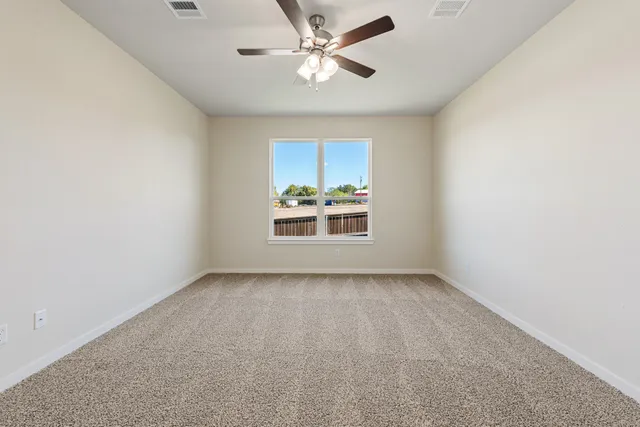 an empty room with a window and a ceiling fan