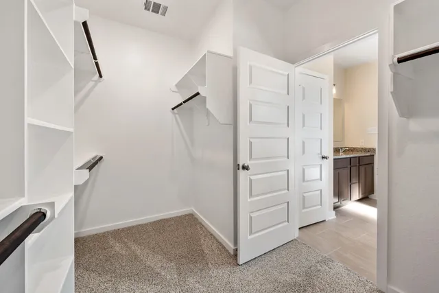 a view of walk in closet with empty racks