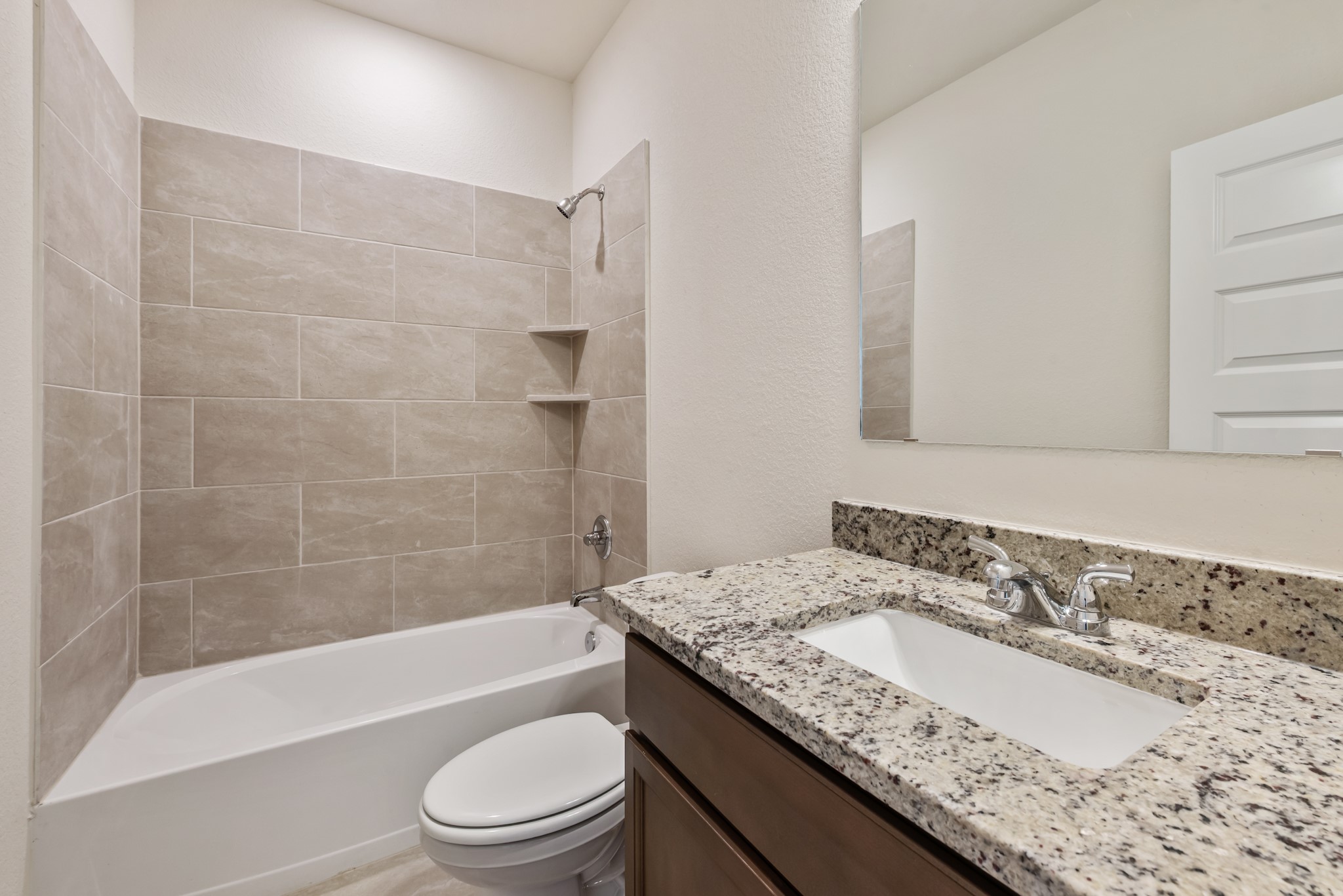 1456 Lk Rdg Drive Brenham, TX 77833 - Photo 6 of 34 a bathroom with a granite countertop sink a toilet and bathtub