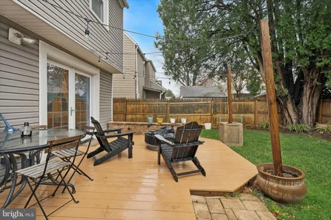 a view of a patio with table and chairs potted plants and a large tree