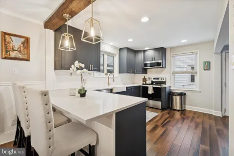 a kitchen with kitchen island a stove a table and chairs in it