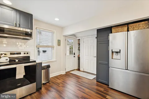 a kitchen with a refrigerator stove and wooden floor