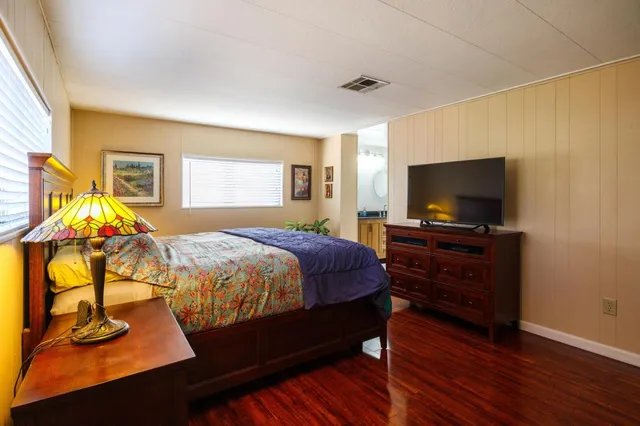 a bedroom with a bed and dresser with mirror