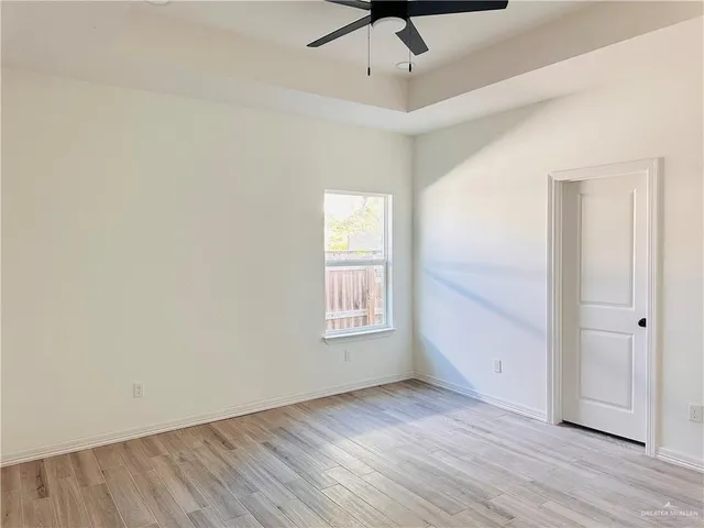 an empty room with wooden floor and window