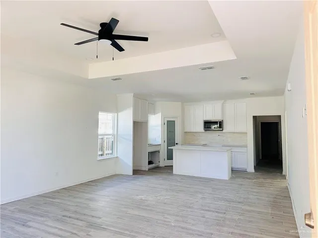 a living room with stainless steel appliances kitchen island furniture and a fireplace