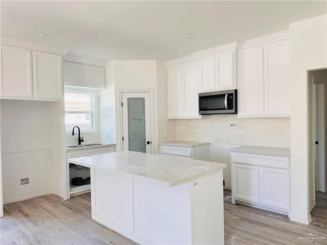 a kitchen with a stove a sink and a microwave