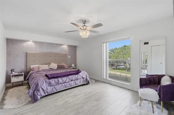 a bedroom with a bed chandelier and a window