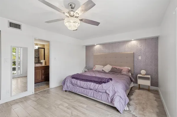 a spacious bedroom with a bed and closet with table