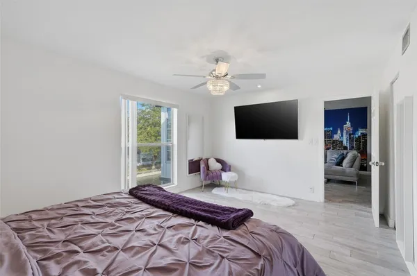 a bedroom with a bed window and a flat screen tv