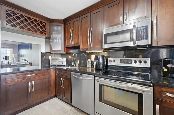 a kitchen with stainless steel appliances granite countertop a stove a sink and a microwave