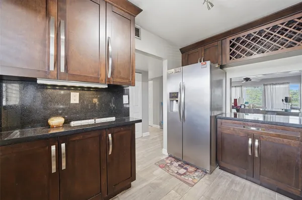 a kitchen with stainless steel appliances granite countertop a refrigerator a sink and a stove