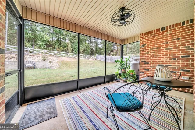 a view of a livingroom with lounge chair and floor to ceiling window