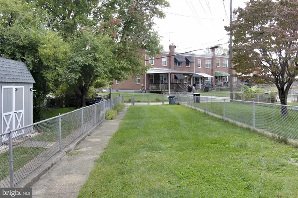 a view of a house with a big yard and large trees