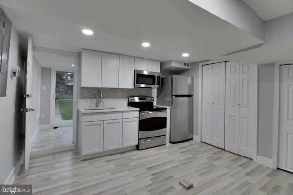 a kitchen with a refrigerator and a stove top oven