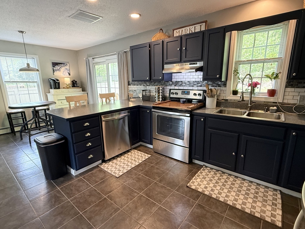 222 Bridge Street Warren, MA 01083 - Photo 5 of 40 a kitchen with stainless steel appliances granite countertop a stove a sink and a microwave