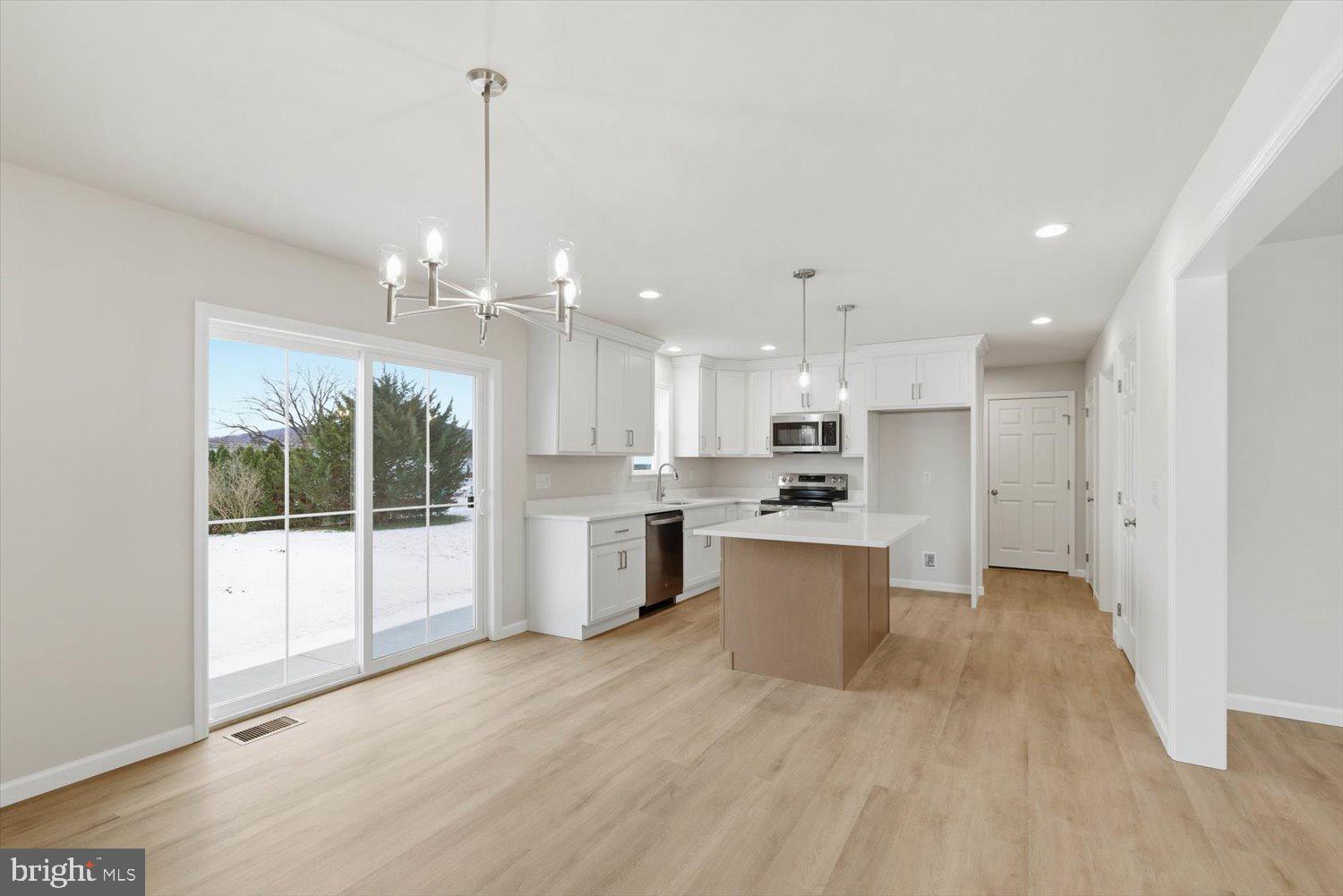 228 Hockersville Road Hershey, PA 17033 - Photo 7 of 36 a large white kitchen with a refrigerator a sink dishwasher a stove and a dining table with wooden floor