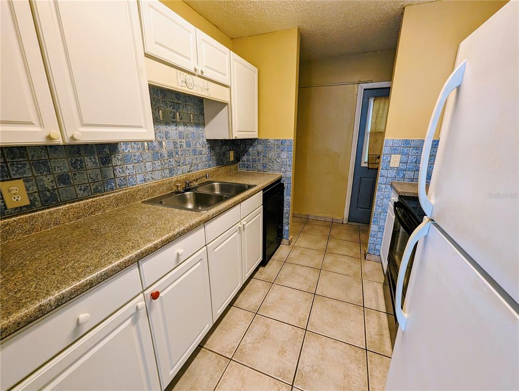 4520 68th Street West, Unit B Bradenton, FL 34210 - Photo 3 of 8 a kitchen with a sink a stove and cabinets