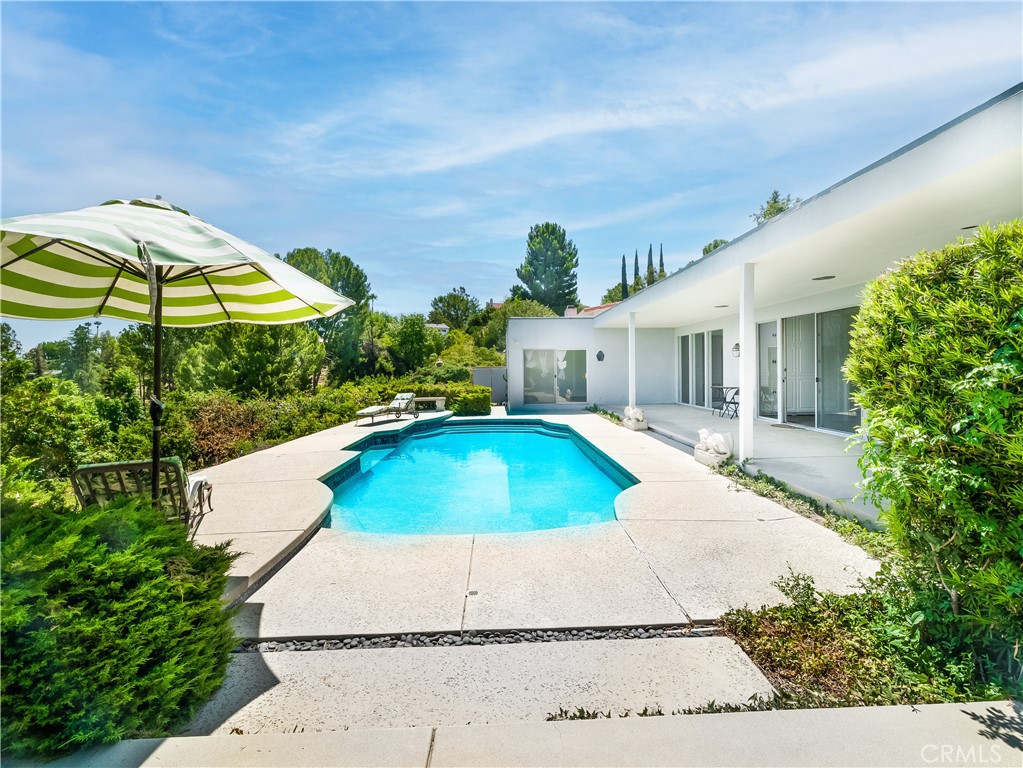 20193 Adele Drive Woodland Hills, CA 91364 - Photo 30 of 38 a house with swimming pool and porch