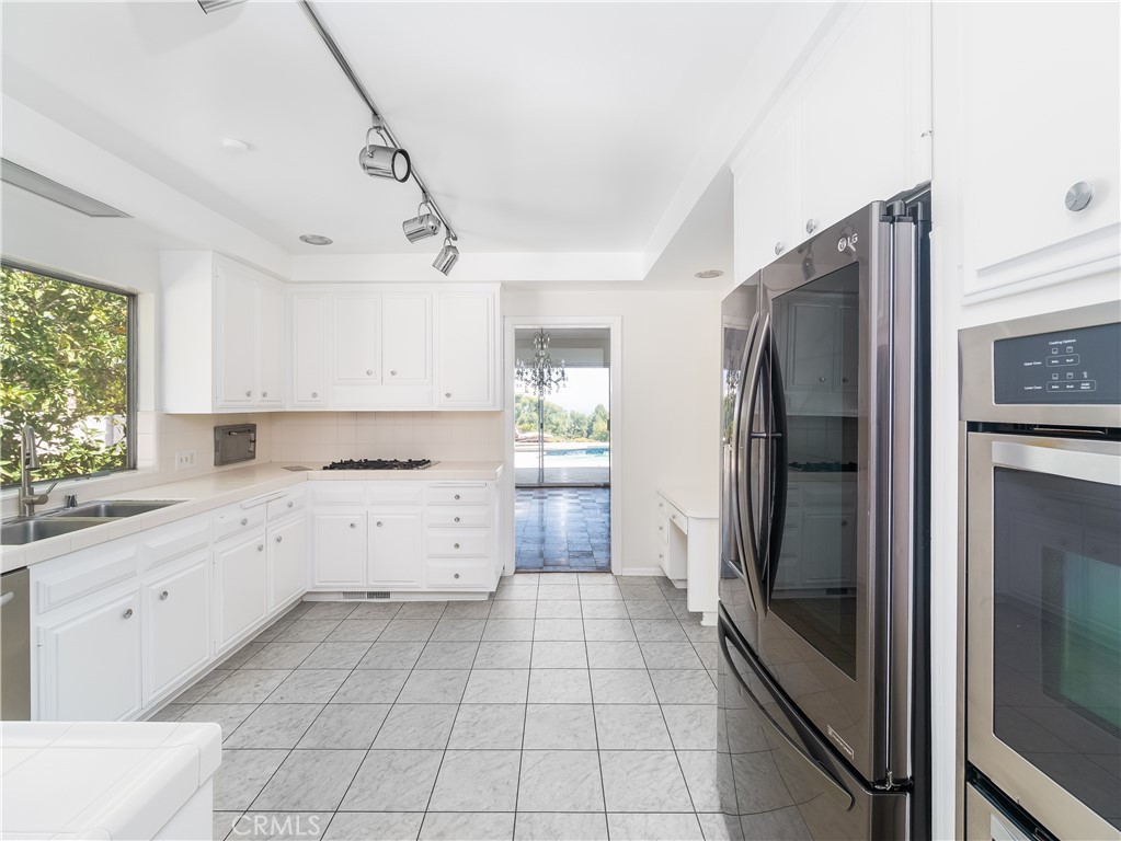 20193 Adele Drive Woodland Hills, CA 91364 - Photo 10 of 38 a kitchen with a refrigerator sink and cabinets