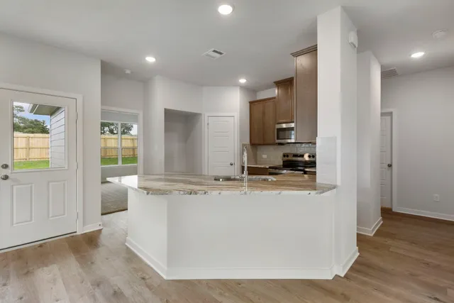 a view of living room with stainless steel appliances granite countertop cabinets and wooden floor