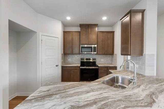 a kitchen with stainless steel appliances granite countertop a sink stove and refrigerator