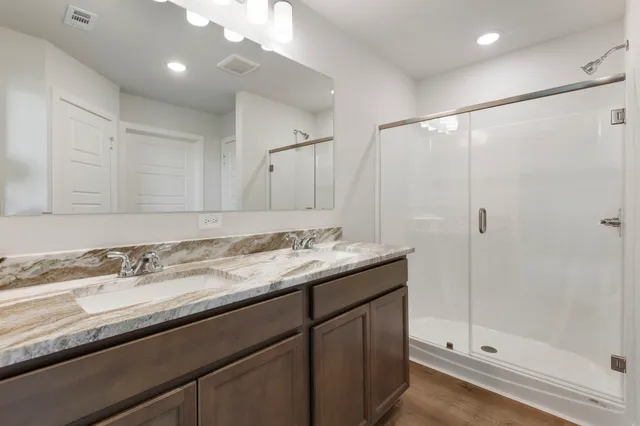 a bathroom with a granite countertop sink a shower and a mirror