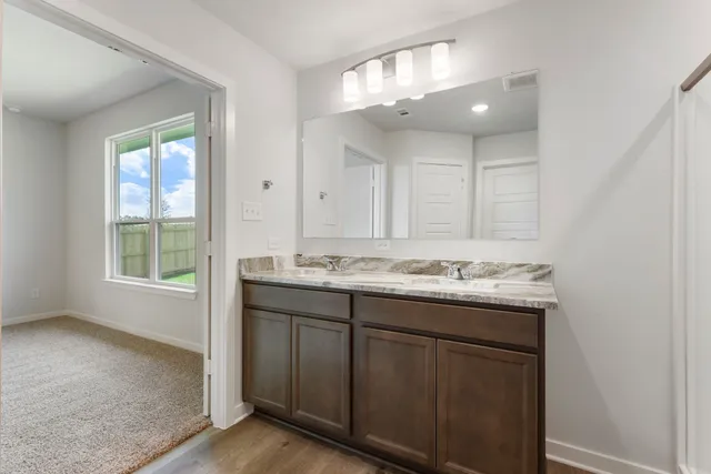 a bathroom with a granite countertop sink and a mirror