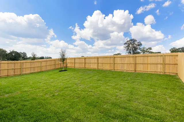 a view of a yard with wooden fence