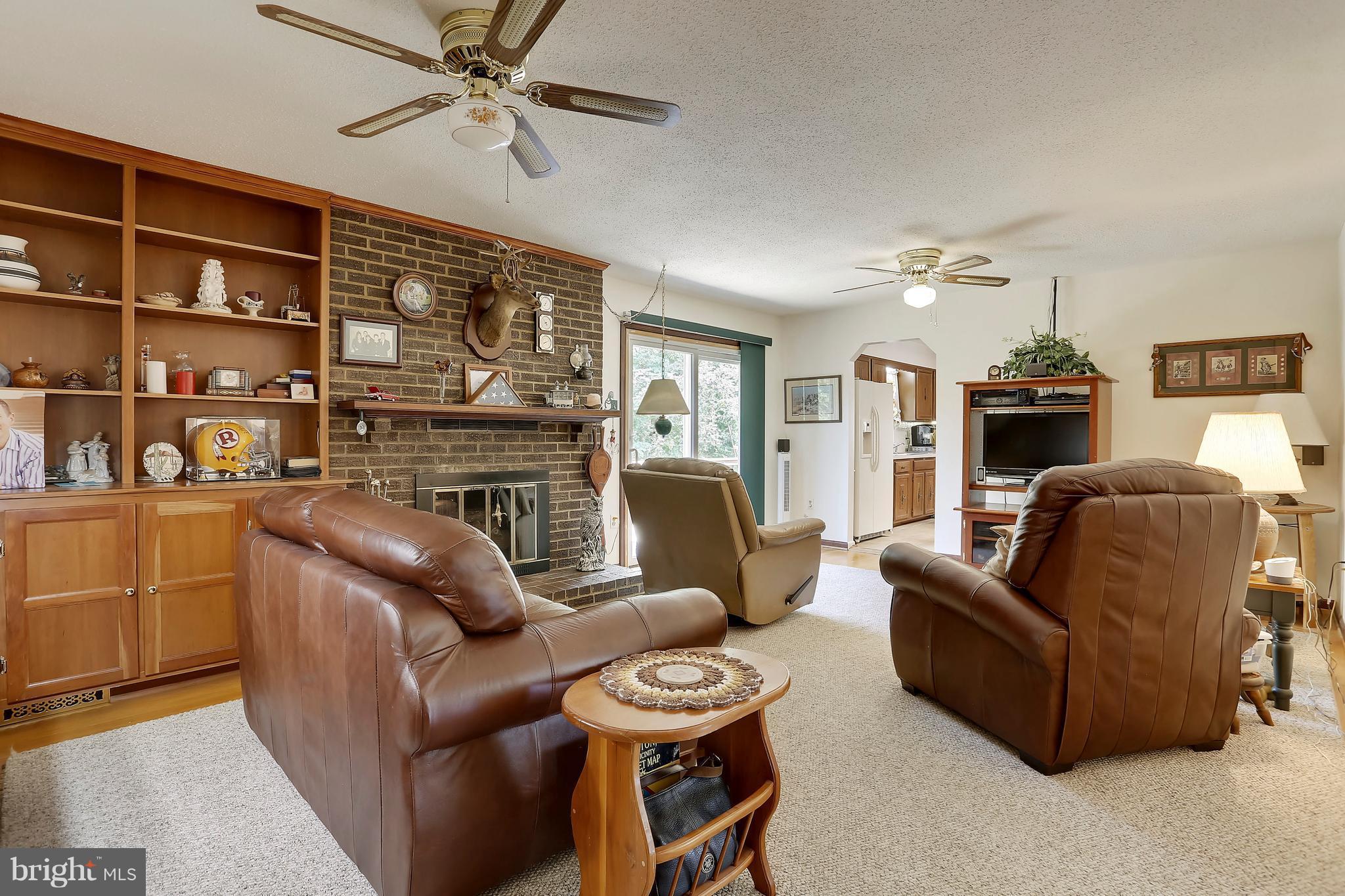 464 Friendship Road Friendship, MD 20758 - Photo 19 of 29 a living room with furniture a fireplace and a chandelier