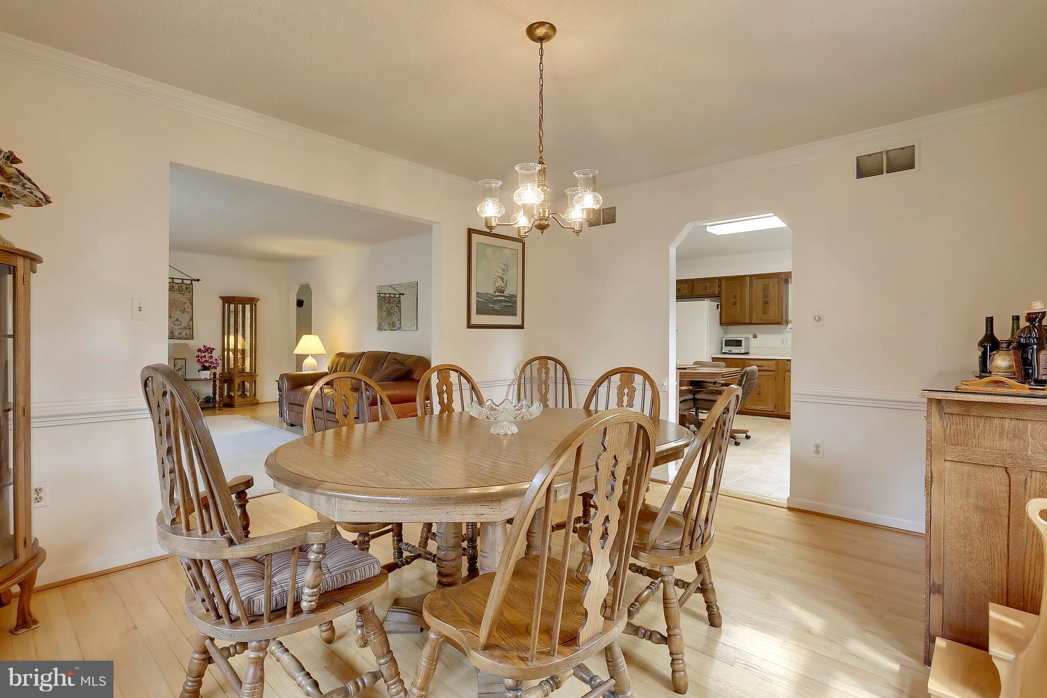 464 Friendship Road Friendship, MD 20758 - Photo 10 of 29 a view of a dining room and livingroom with furniture wooden floor a chandelier