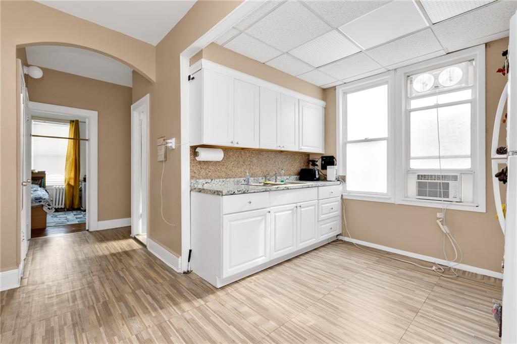 449 Ave Y Brooklyn, NY 11223 - Photo 14 of 25 a kitchen with wooden floors and white cabinets