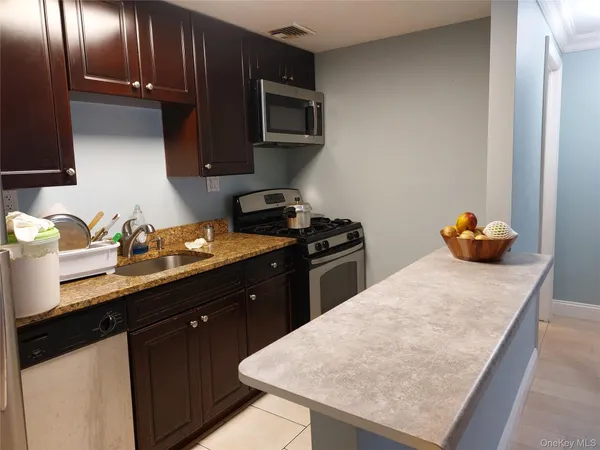 a kitchen with stainless steel appliances granite countertop a sink stove and microwave