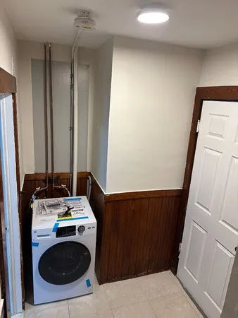 a storage room with wooden floor and washing machine