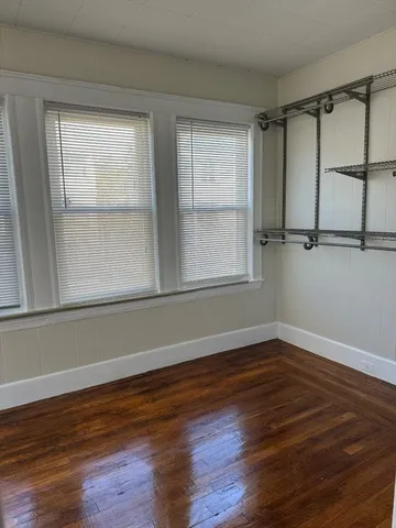 a view of a room with wooden floor and window