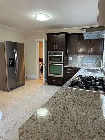a kitchen with a stove a refrigerator and a cabinets