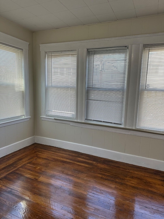 78 Harriet Street, Unit 1 Boston, MA 02135 - Photo 21 of 22 a view of an empty room with wooden floor and a window