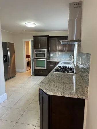 a kitchen with a stove a refrigerator and cabinets