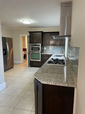 a kitchen with a stove a refrigerator and cabinets
