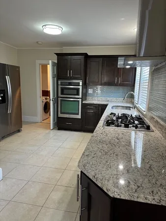 a kitchen with kitchen island a stove and a refrigerator