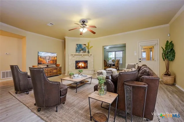 a living room with fireplace furniture and a wooden floor